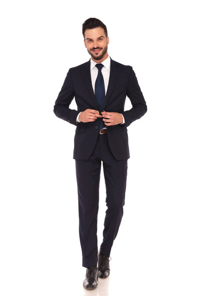 glücklicher junger Geschäftsmann schließt seinen Anzug und lächelt - Foto, Bild