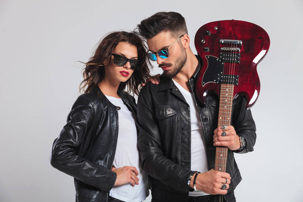 hombre mostrando su guitarra eléctrica con mujer a su lado
 - Foto, imagen