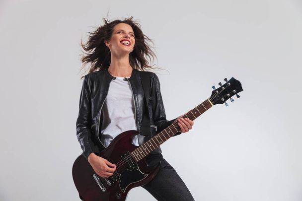 laughing woman guitarist enjoying herself while playing electric - 写真・画像