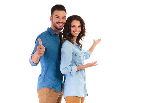 couple presenting something and man makes the ok sign  - Фото, изображение
