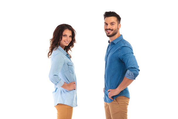 smiling young casual couple with hands on waist  - Photo, Image