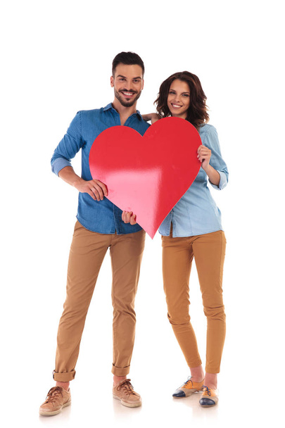 young in love couple holding big red heart - Foto, Bild