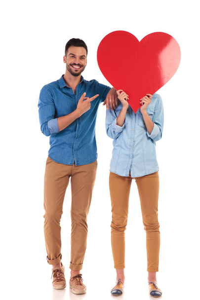 smiling man pointing to the big heart over woman's  face - Photo, Image