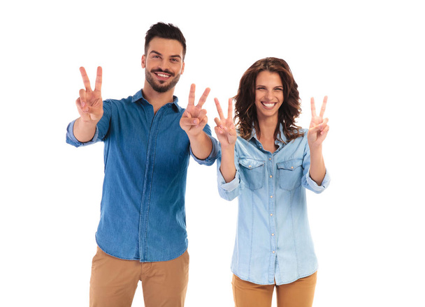 happy laughing casual couple making the victory sign  - Foto, Imagen