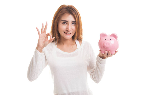 Asian woman show OK  with pig coin bank. - Zdjęcie, obraz