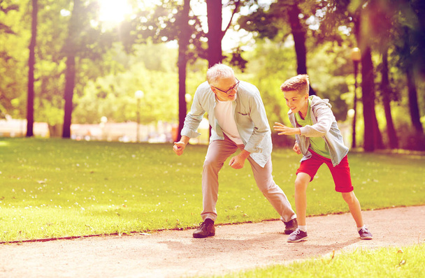 grandfather and grandson racing at summer park - 写真・画像