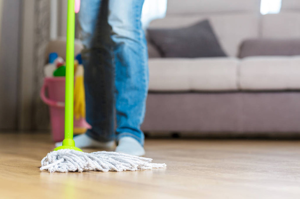 woman in protective gloves using a wet-mop while cleaning floor - Foto, Imagem