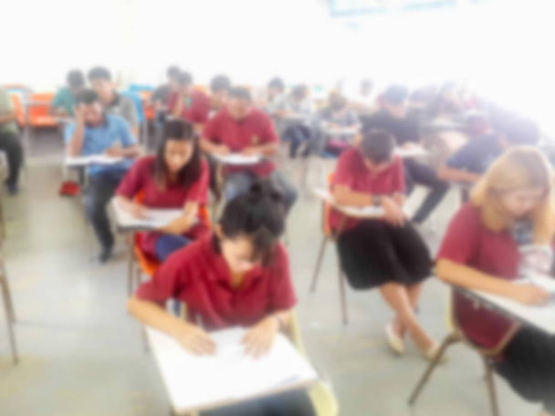 Escuela desenfocada o estudiantes universitarios escribiendo respuesta
 - Foto, imagen