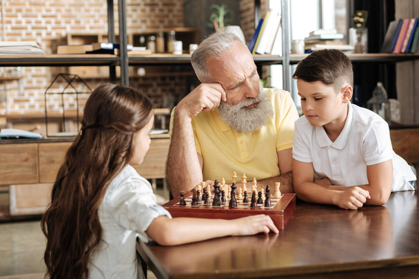 Grandfather giving his grandson a tip in chess game - Fotografie, Obrázek