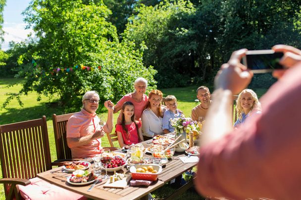 feliz familia fotografiando por teléfono inteligente en verano
 - Foto, Imagen