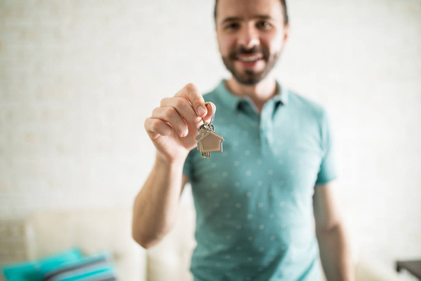 Homem hispânico mostrando chaves
 - Foto, Imagem