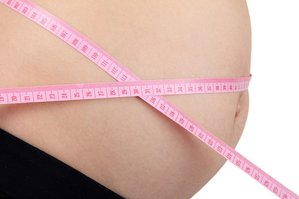Pregnant woman with pink tape measure - Photo, Image