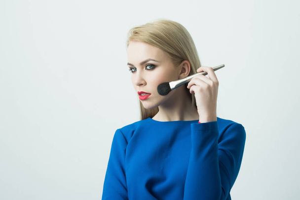 makeup brush at blonde girl with red lips - Fotografie, Obrázek