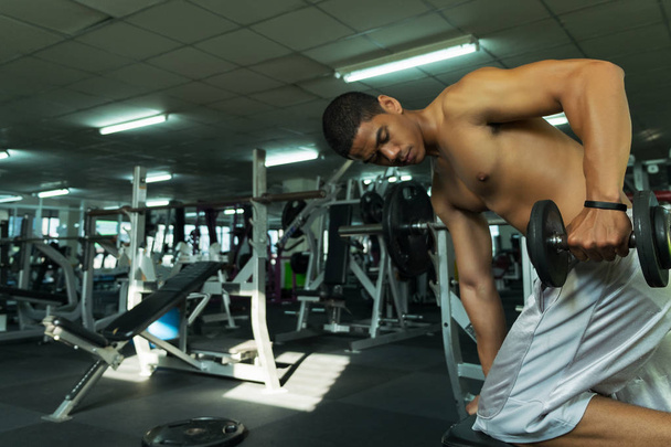 Fitness άνθρωπος στην κατάρτιση δείχνει ασκήσεις με αλτήρες στο γυμναστήριο, fitness έννοια, έννοια του αθλητισμού - Φωτογραφία, εικόνα
