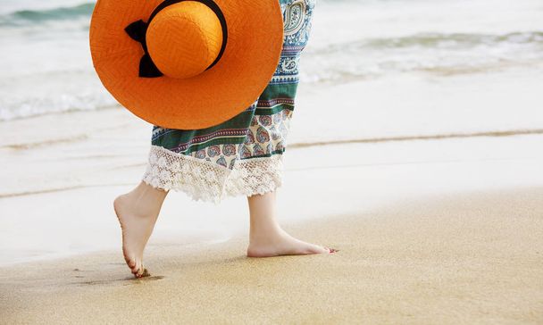 Barefoot woman walking on the ocean beach sand and enjoy the vacation during the tourist trip  - Foto, afbeelding