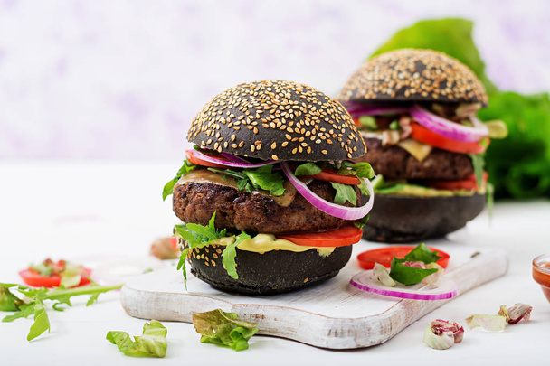 beyaz kesme tahtası üzerinde siyah hamburger - Fotoğraf, Görsel