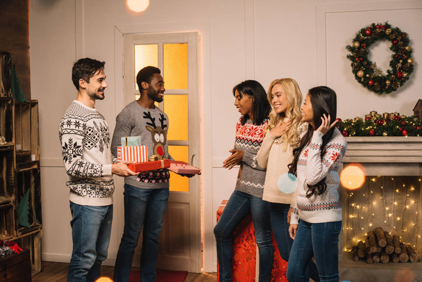 Multikulturelle Freunde tauschen Weihnachtsgeschenke aus - Foto, Bild