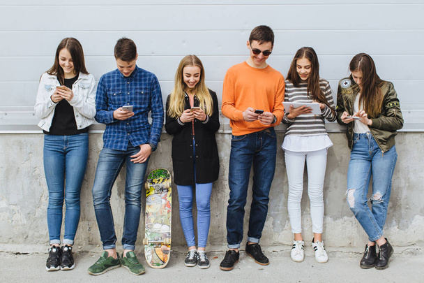 Группа подростков на улице с мобильными телефонами
 - Фото, изображение
