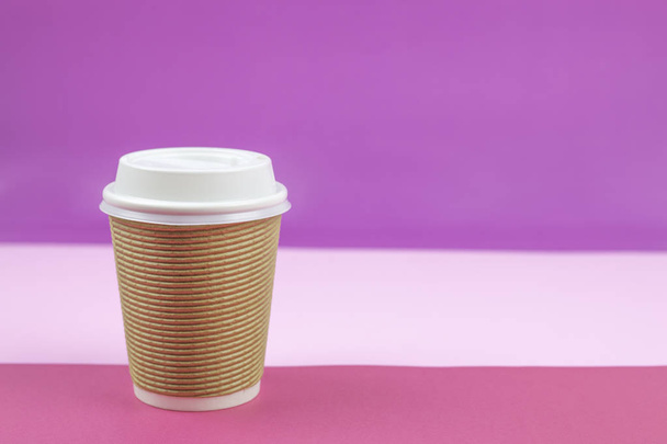 Saque la taza de café de papel sobre fondo púrpura y rosa
.  - Foto, imagen