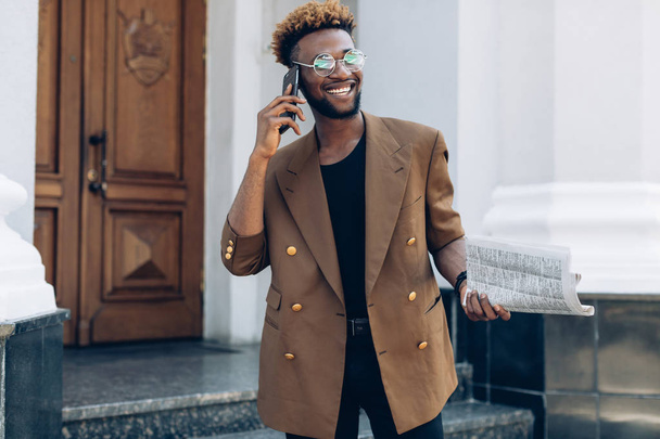 Man in a jacket with phone in city - Photo, Image