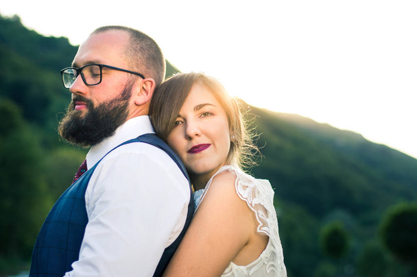 Bride and groom in romantic hug at sunset - Photo, Image