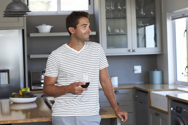 man with glass of wine in kitchen  - Photo, image