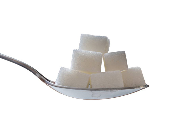 Lähikuva lusikalla, jossa on paljon sokerikuutioita. Eristetty valkoisella
  - Valokuva, kuva