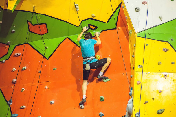 Man climber on artificial climbing wall  - 写真・画像