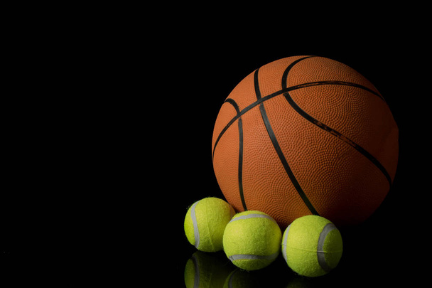 A single basketball isolated on a black background with three te - Foto, afbeelding