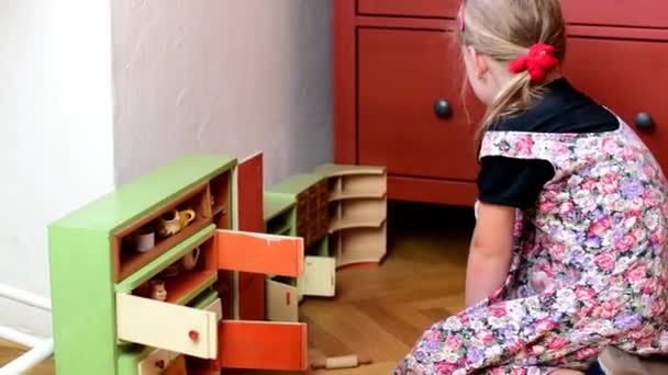 niedliches kleines Mädchen spielt mit Vintage-Spielzeug. Mädchen Körper, Mädchen trägt geblümtes Kleid - Filmmaterial, Video