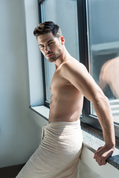 shirtless man leaning back on windowsill - Photo, Image