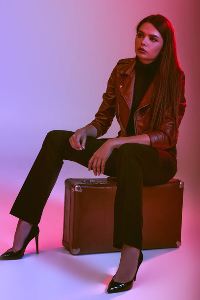 model sitting on suitcase - Фото, зображення