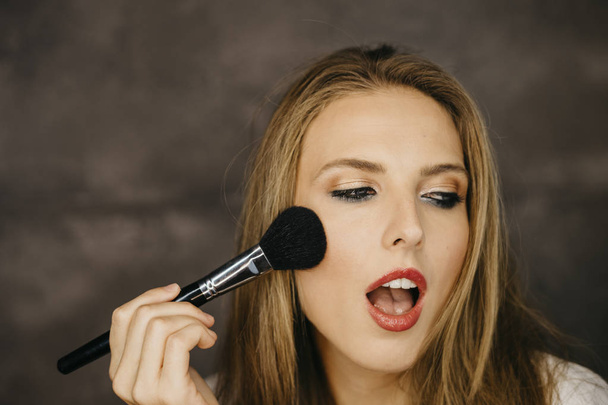 beautiful young woman applying makeup  - Φωτογραφία, εικόνα