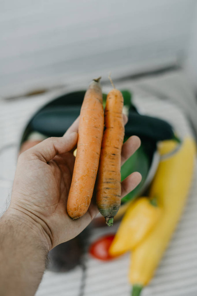 Home carrots in vegan man hand - Photo, Image