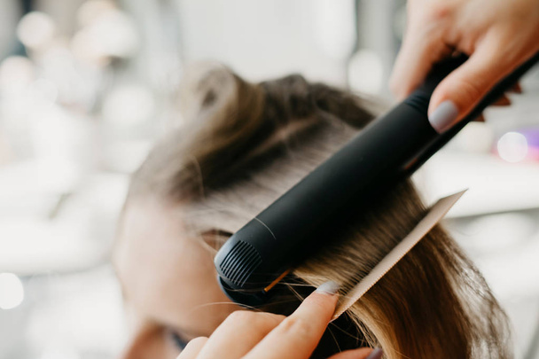 Девушка делает укладку волос в салоне
 - Фото, изображение