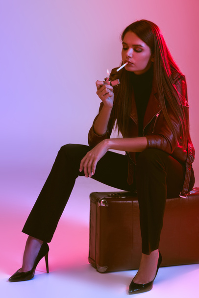 smoking girl sitting on suitcase  - Fotoğraf, Görsel