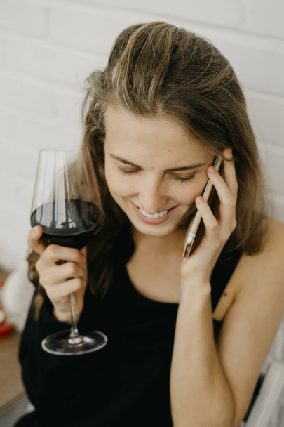 Woman with wine holding phone in hand - Foto, Imagem