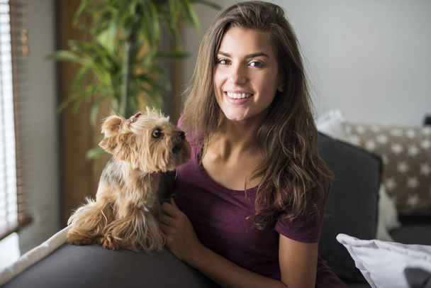 woman sitting on sofa with her dog  - Photo, Image