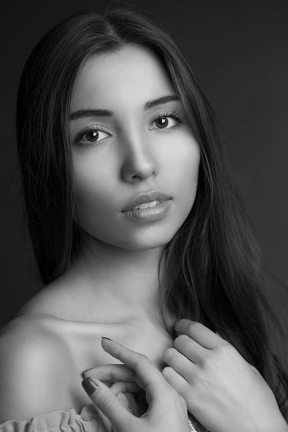Beauty portrait of a young beautiful brunette girl with long straight flying hair. Magnificent hair. Black and white. - Foto, Bild