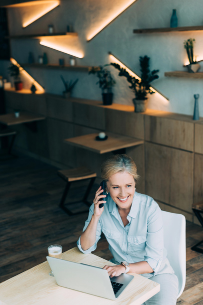 businesswoman talking on smartphone in cafe - Photo, Image