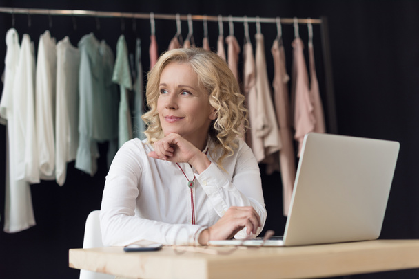 businesswoman with laptop in clothing store - Fotoğraf, Görsel