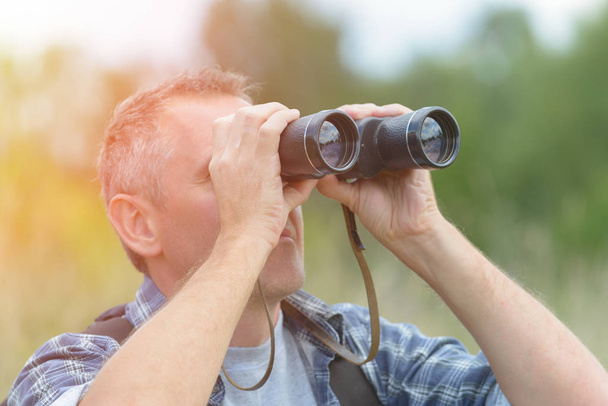  Hombre mirando a través de binocular
 - Foto, Imagen