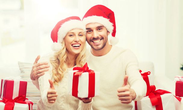glückliches Paar mit Weihnachtsgeschenken und Daumen hoch - Foto, Bild