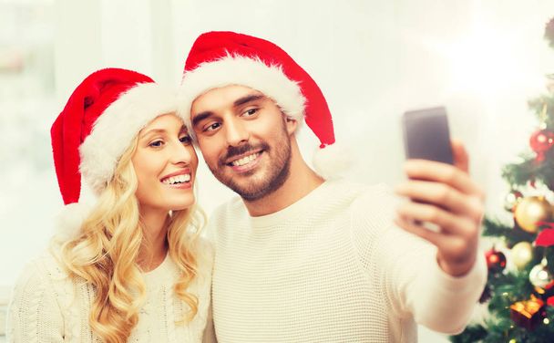 couple taking selfie with smartphone at christmas - Photo, Image