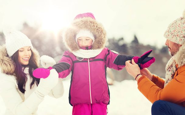happy family with child in winter clothes outdoors - Foto, imagen
