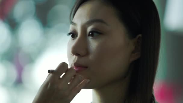 Makeup artist applying lipstick on women's lips - Záběry, video