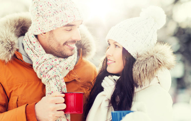 ευτυχισμένο ζευγάρι με κύπελλα τσάι κατά τη διάρκεια χειμερινό τοπίο - Φωτογραφία, εικόνα