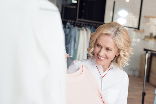 woman choosing clothes in clothing store - Valokuva, kuva