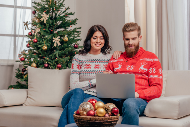 casal feliz usando laptop no Natal
 - Foto, Imagem