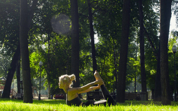 Nuori nainen tekee jooga harjoituksia puistossa - Valokuva, kuva